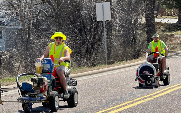 People Riding Striping Vehicles Down Street