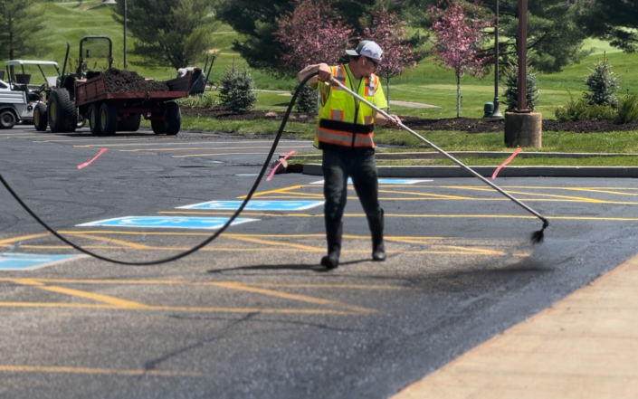 Person Covering Old Parking Spots With Spray
