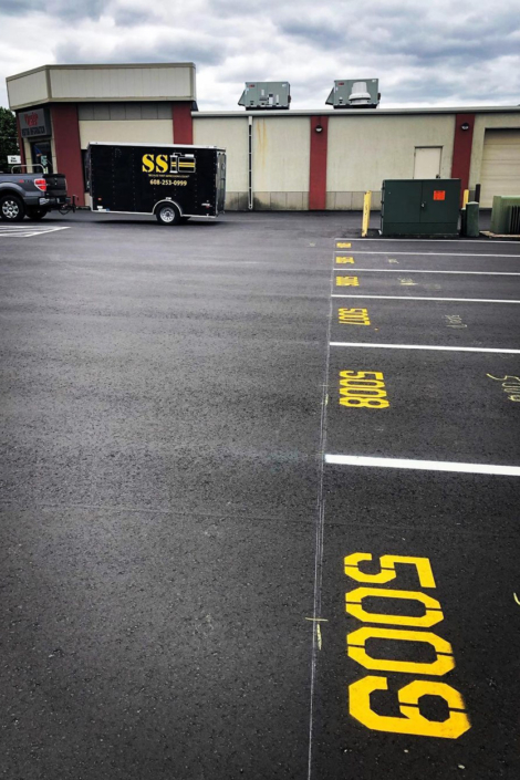 Ssi Trailer On Back Of Truck In Front Of Painted Parking Lot