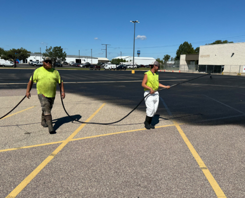 Ssi Workers Painting A Seal Coating On Parking Lot