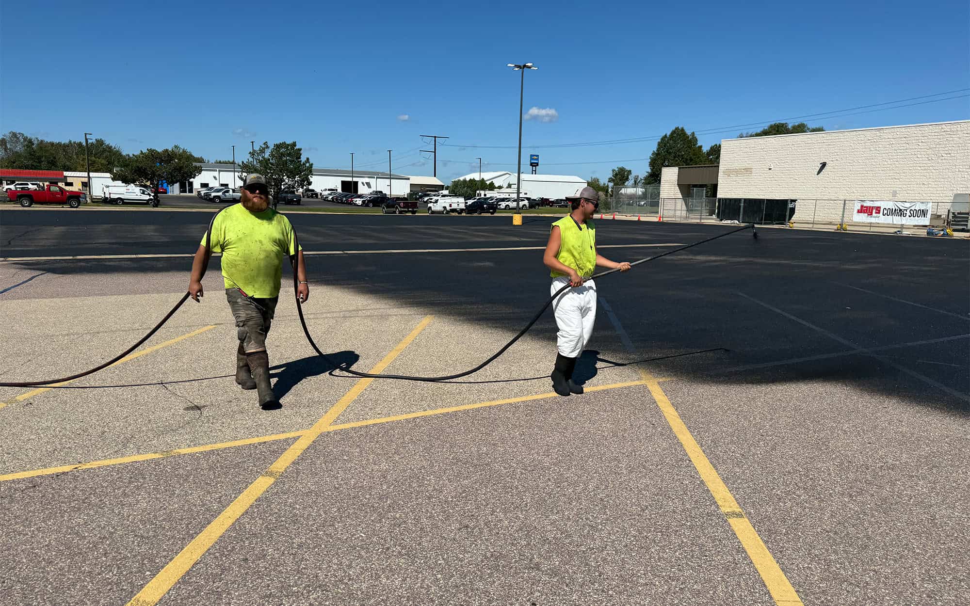 Ssi Workers Painting A Seal Coating On Parking Lot