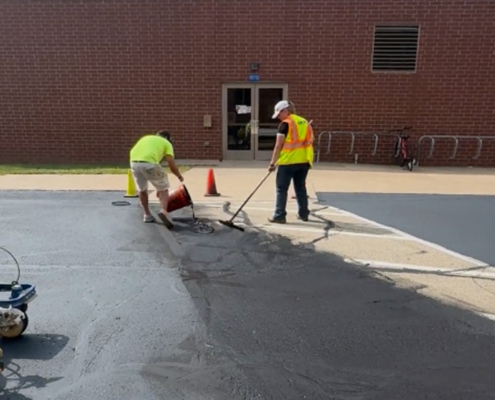 Two Ssi Workers Repairing Cracks In Parking Lot