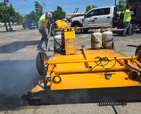 Workers Filling Pothole With Large Machine
