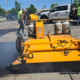 Workers Filling Pothole With Large Machine