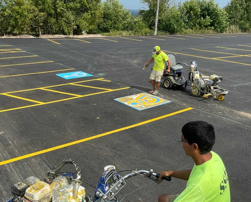 Workers At Ssi Painting Lines In Parking Lot