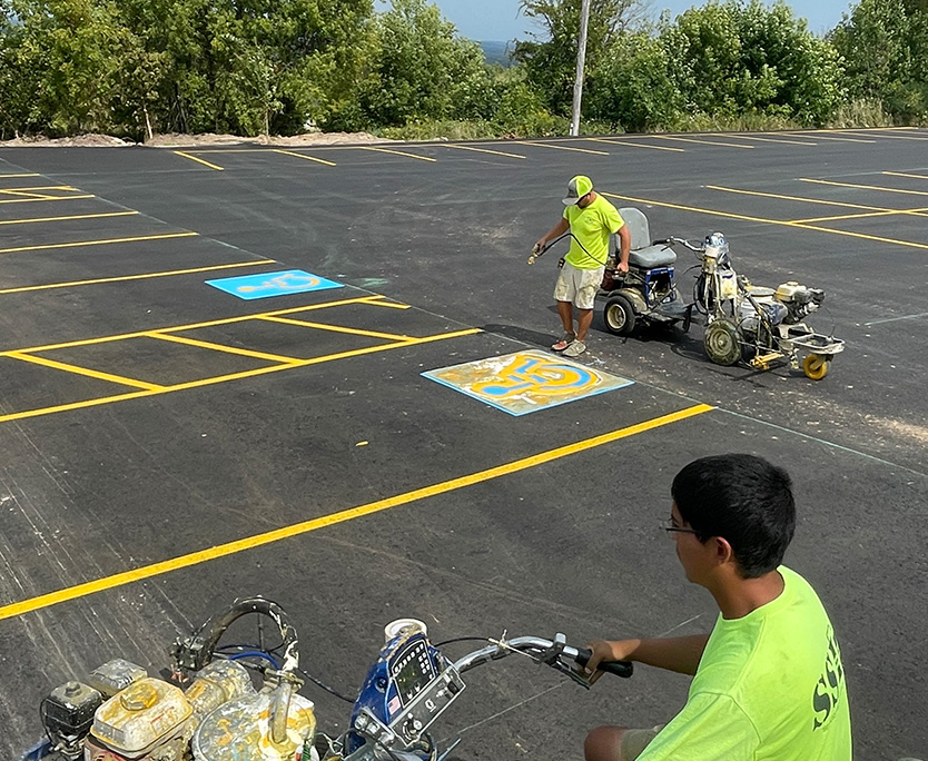Workers At Ssi Painting Lines In Parking Lot